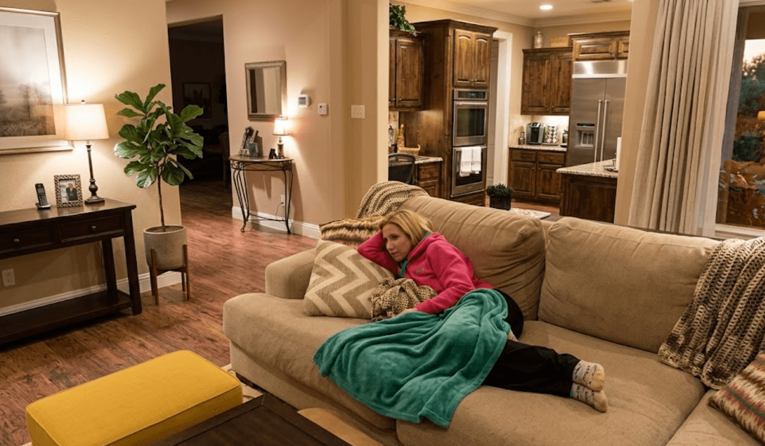 Woman lying exhausted on couch covered in blankets, experiencing severe mold fatigue from mycotoxin illness