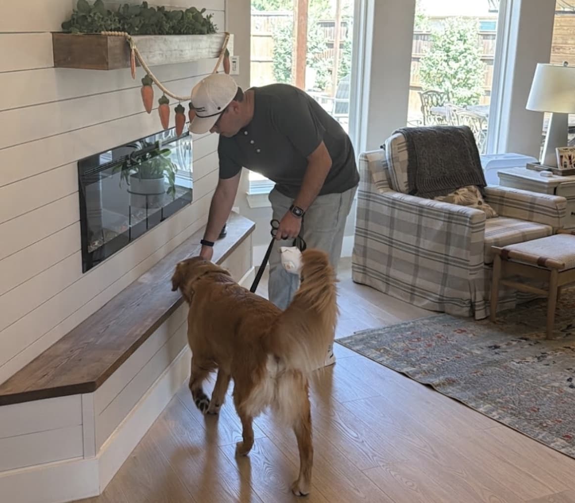 Mold inspector Dr. Tate Barrett of Barrett Environmental and Scout, a trained mold detection dog, checking a living room wall for hidden mold